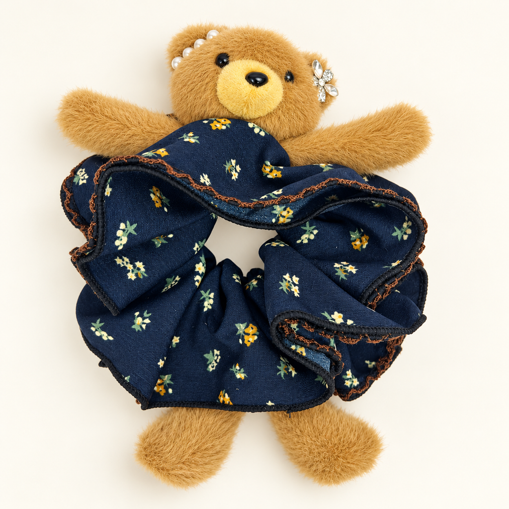 Brown teddy bear with navy floral ruffle scrunchie and decorative head accents