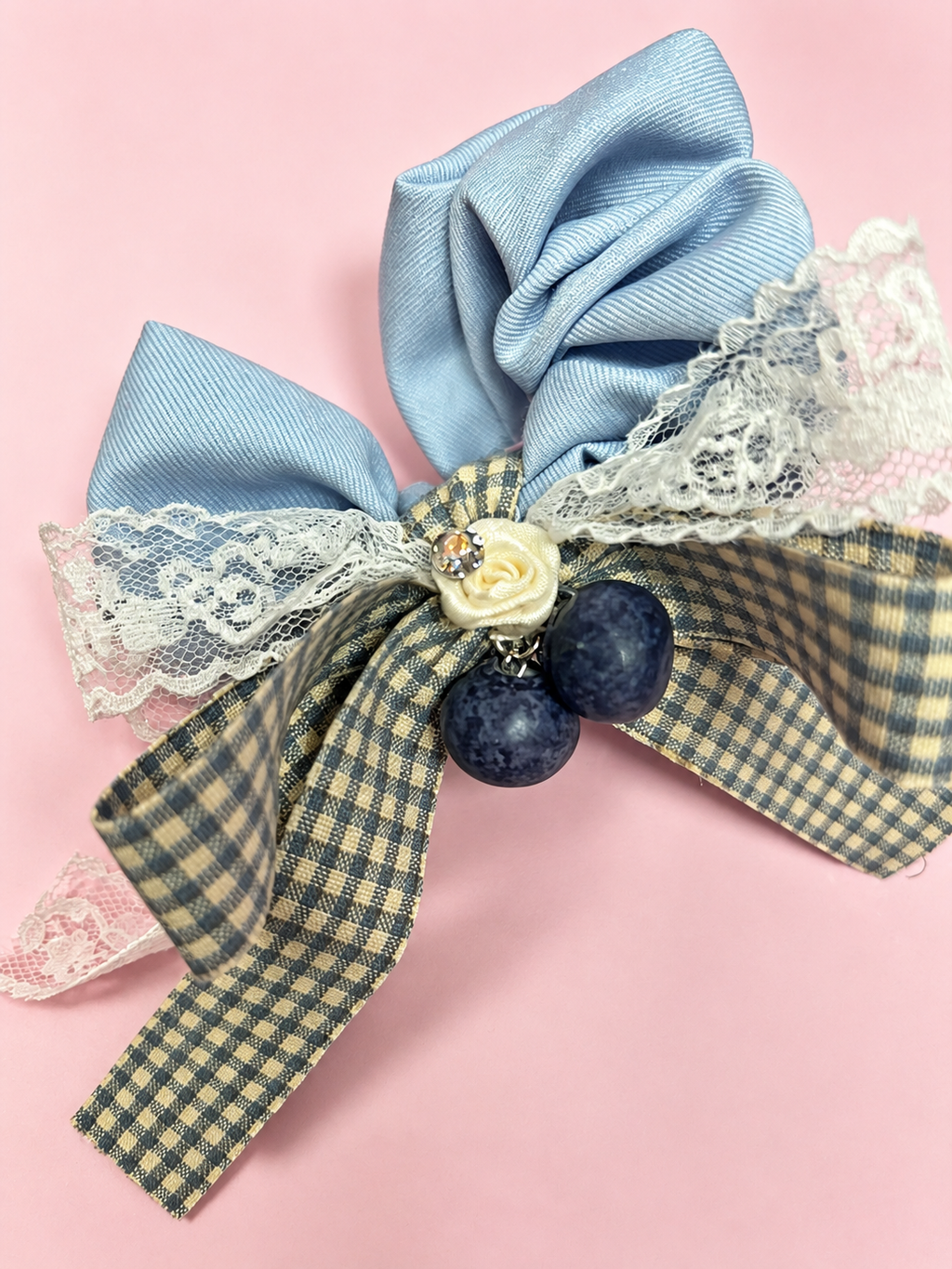 Close-up of blue gray fabric scrunchie with gingham and lace bow