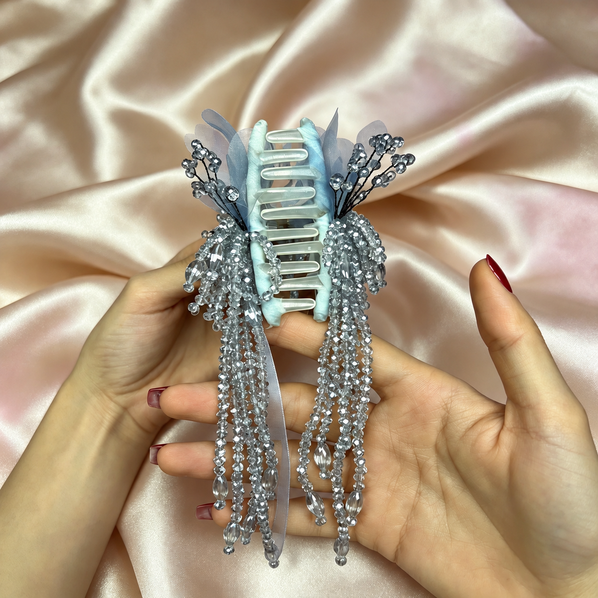 Front of handmade ice blue hair claw with cascading clear glass bead dangles
