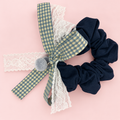 Navy fabric scrunchie with gingham bow, white lace and gray pom pom charms