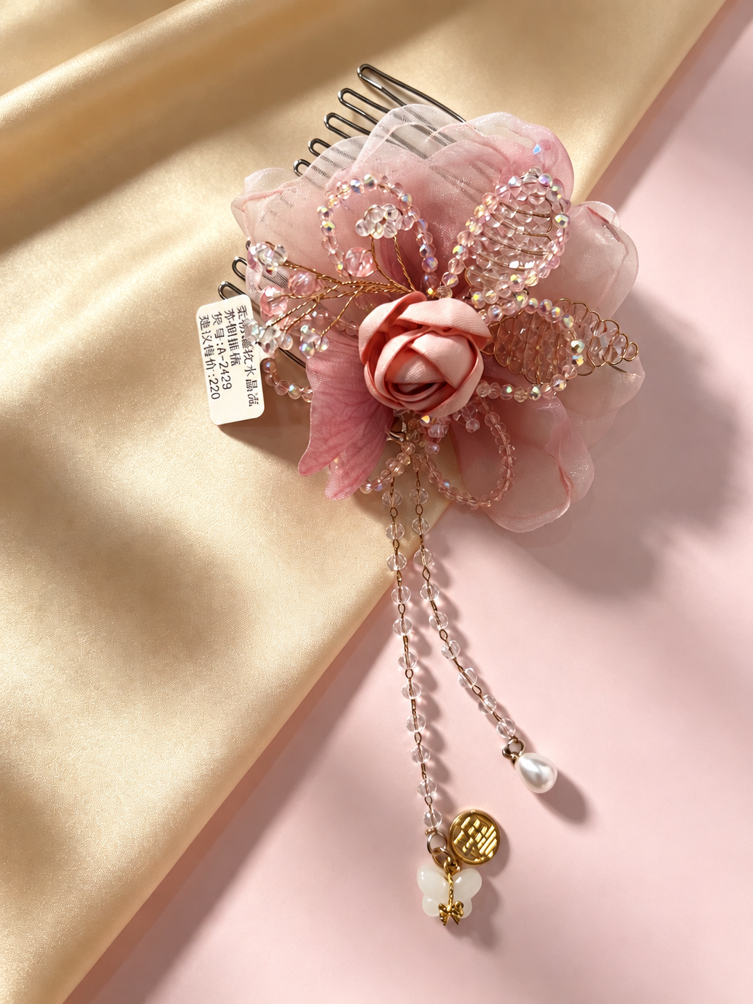 Pink rose and beaded butterfly hair comb on satin